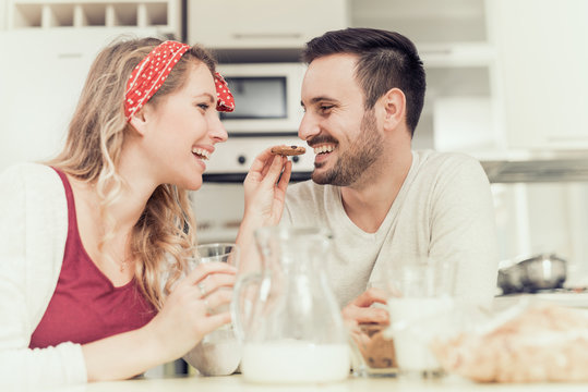 Happy young couple having breakfast at home