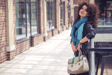 Brunette beautiful stylish caucasian woman in casual outfit on a walk on european city street. copy space