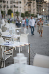White cafe tables on the street of the spa town in the evening
