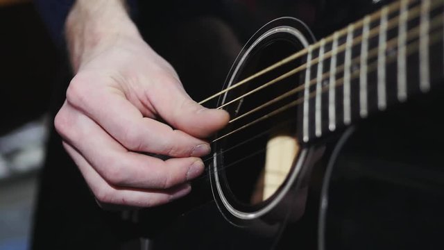 Acoustic black guitar playing, close up shot Slow motion