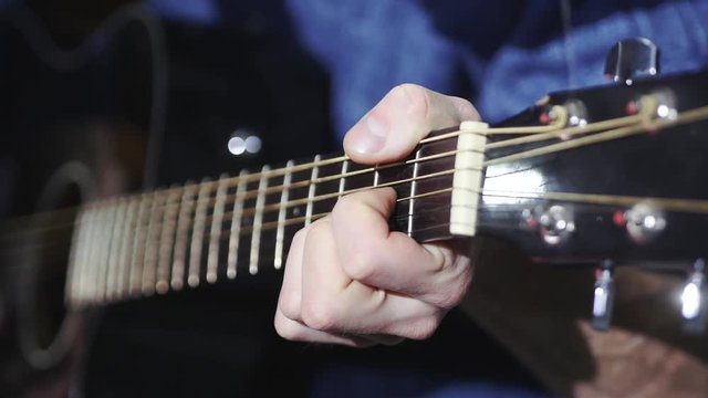 man playing guitar close up, transposes chords