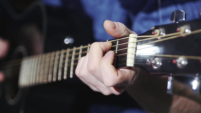 man playing guitar close up, transposes chords, slow motion