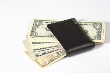 Black leather wallet left unguarded. The wallet is full of cash. US dollars coming out of it.