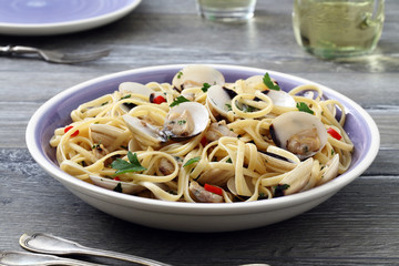 pasta spaghetti con le vongole  sfondo tavolo di cucina grigio