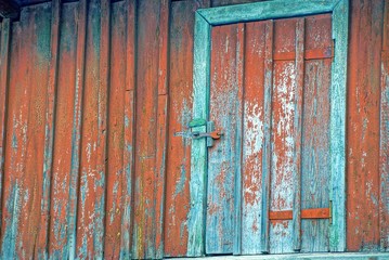 Fototapeta na wymiar Старая дверь на красной деревянной стене