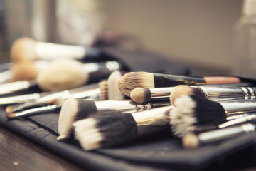 Obraz na płótnie Canvas Set of brushes (make up application tools) laying on a table randomly