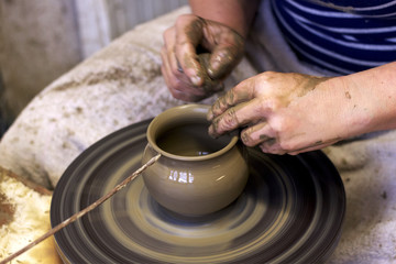 Fototapeta na wymiar closeup of hands working on pottery wheel, clay pot 
