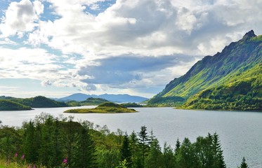 Mountains reflecting over clear turquoise water in the Lofoten Islands, Norway