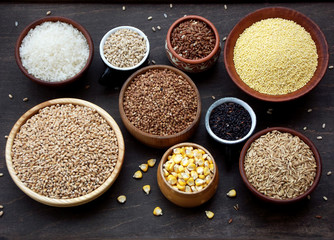 assortment of different cereals and seeds in bowl: wheat, oats, barley, rice, millet, buckwheat,...