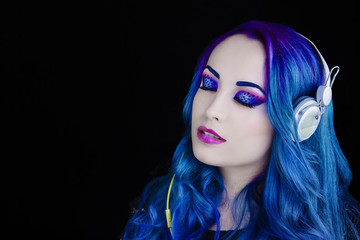 Portrait d'une jolie fille aux cheveux bleu écoutant de la musique les yeux fermés