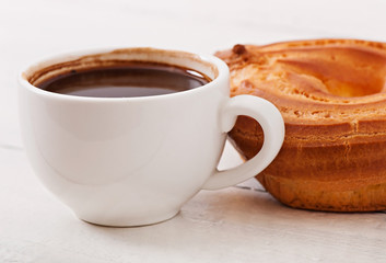 Cup of coffee and delicious baked cookies on old wooden background.