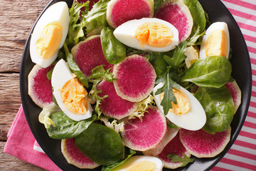 Salad with radishes, eggs, spinach and lettuce mix close-up. horizontal top view
