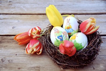 Obraz na płótnie Canvas Osternest mit Eiern und Tulpen