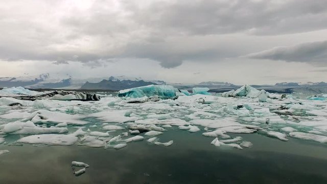 The camera pans across the glaciers of Jökulsarlon. It is a large glacial lake in southeast Iceland, on the edge of Vatnajökull National Park.