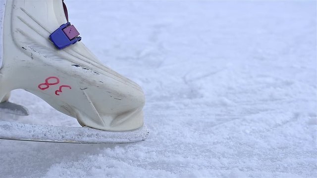 Low angle view of ice skater stopping before camera
