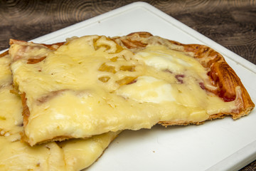 Hand made pizza with pepperoni, tomatoes, olives and basil on white cooking boards