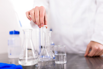 Fototapeta premium Hand of a Scientist Holds Laboratory Glassware