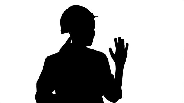 Silhouette Smiling female engineer with digital tablet taking to the camera 