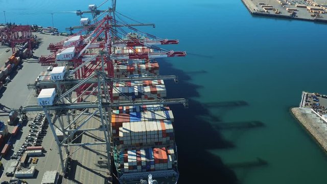 Shipyard Aerial v29 Flying low over large commercial ship in shipyard panning down.