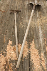 Shovel and rake on an old wooden boards. The concept of gardening