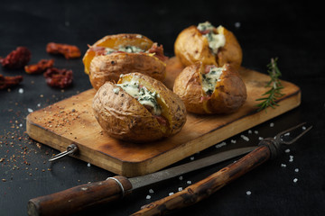 Baked potatoes with prosciutto and cheese - 138009965
