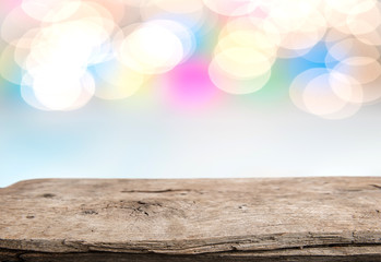 Fototapeta premium Rrustic wood table in front of glitter and bright bokeh lights
