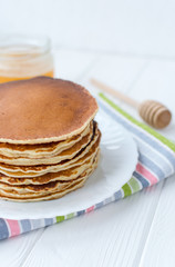 Healthy breakfast. Stack of delicious, homemade pancakes with honey, cherry and banana on white plate 