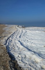 Winterlicher Strand an der Ostseeküste unter Eis und Schnee
