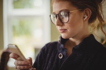 Woman using mobile phone at home