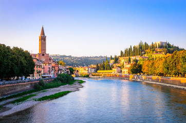 Beautiful old houses on Adige river and tower of Santa Anastasia church in Verona, Veneto region, Italy.