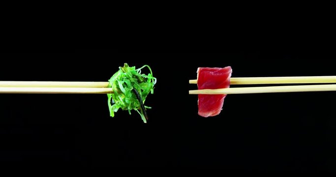 Macro shot of sushi,sashimi,uramaki and nighiri.typical Japanese dish consisting of rice, salmon or tuna,shrimp and fish eggs on a black background.Concept:Japanese restaurant,sushi,oriental tradition
