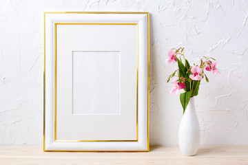 Gold decorated frame mockup with flower bouquet in elegant vase