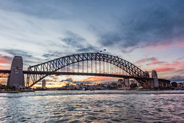 Australian iconic landmark Sydney Harbour Bridge against picturesque sunset sky