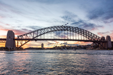 Australian iconic landmark Sydney Harbour Bridge against picturesque sunset sky