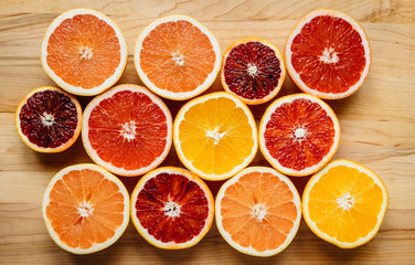 Colorful assorted grapefruits and citrus on a wooden table from above
