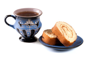 slices of biscuit roll with a cup of tea isolated on white background closeup