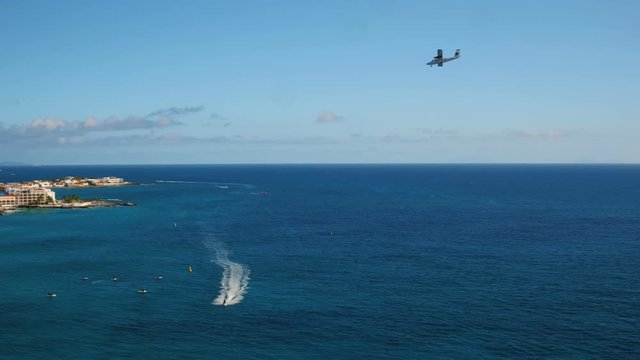 St Maartin Aerial v56 Flying low over bay panning with views of Simpson Bay and small plane landing.
