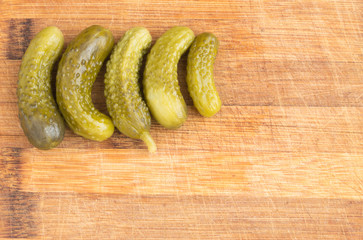 Homemade Pickled Gherkins or Cucumbers Over Rustic Wooden Background