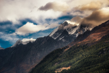 Fototapeta na wymiar Mountainside with peaks shrouded in cloud