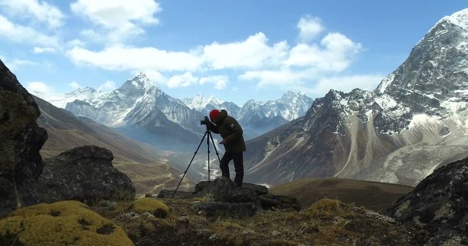 Man makes photos, in the mountains of Nepal. Photo tour to the base camp of Mount Everest. Ama Dablam view, from Awi peak, 5200 m). Awi peak is a part of Everest Base Camp trek. 