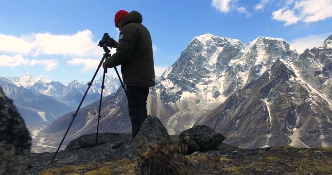  Man makes photos, in the mountains of Nepal. Photo tour to the base camp of Mount Everest. Ama Dablam view, from Awi peak, 5200 m). Awi peak is a part of Everest Base Camp trek. 