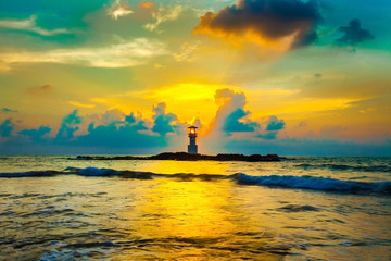 sunset and beach. Beautiful sunset above the sea and lighthouse on the rock