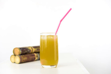 Fresh sugar cane juice in glass on table white background