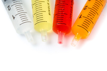 Syringe with colorful kids medicine syrup on white background