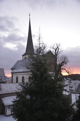 Fototapeta na wymiar Sunrise over snow covered rooftops in January in Bavaria, Germany