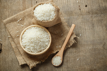 Jasmine rice in bowl and sack on wooden table