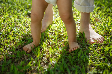 Portrait of mother and baby legs. First steps.