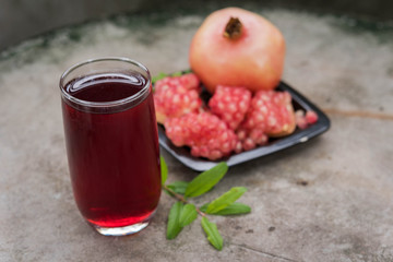 Glass of pomegranate juice with fruit outdoors
