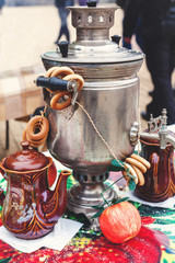 Samovar, bagels and tea on bright tablecloth on holiday carnival