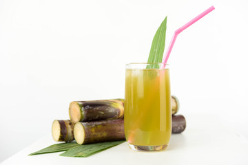 Fresh sugar cane juice in glass on white background